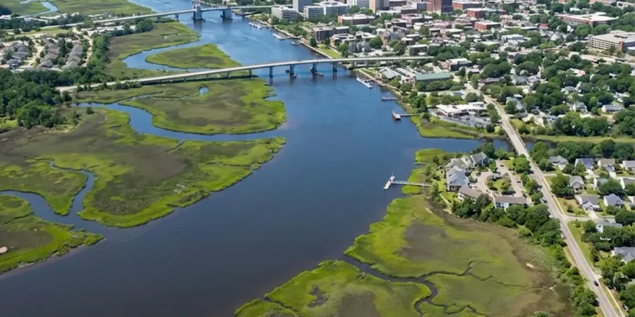 Aerial view of coastal North Carolina city along a wide river with marshland and waterfront neighborhoods